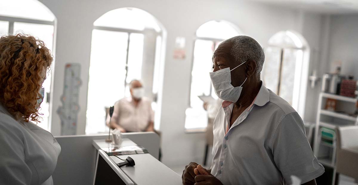 Patient in mask talking to healthcare worker in mask