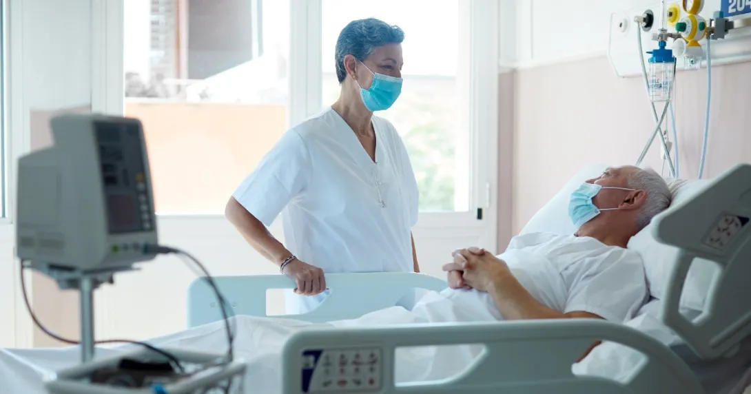 doctor speaks to a hospital patient in bed