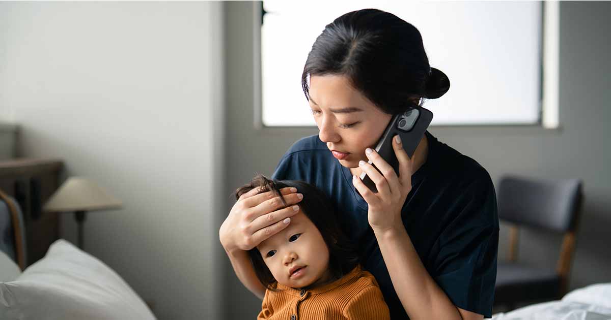 Person holding child while talking on the phone