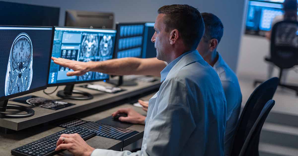 Workers looking at an xray image on a monitor