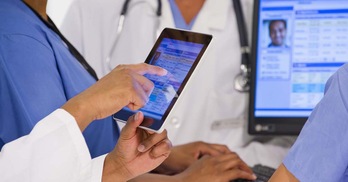Healthcare workers looking at a medical record on a tablet