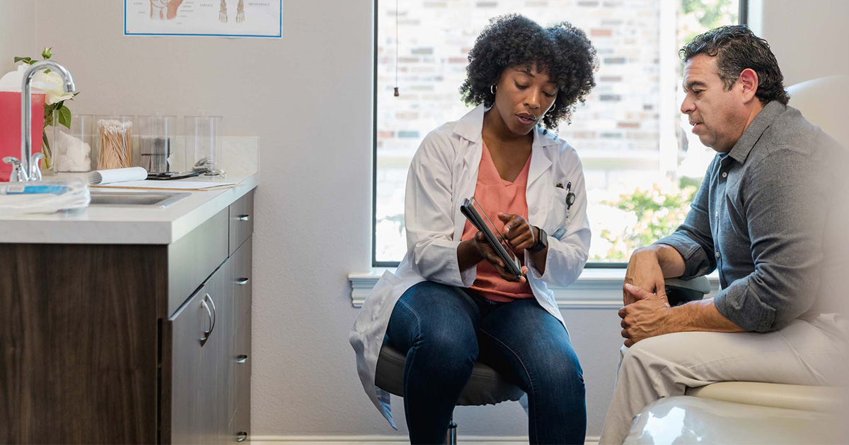 Doctor showing tablet to patient