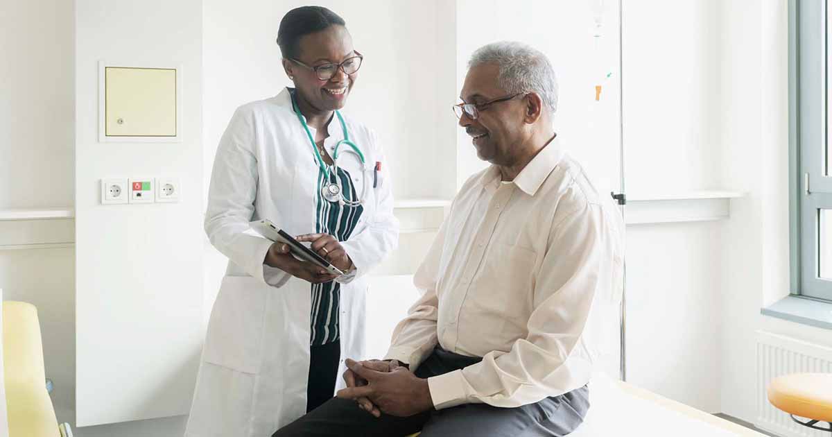 Doctor showing tablet to patient