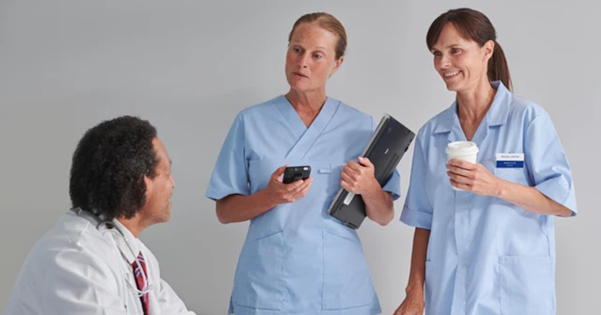 Hospital staff, with one holding the Ascom Myco 4,  in a conversation