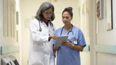 doctor and nurse discuss EHR issues in clinical setting