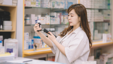 Pharmacist scanning pill bottle