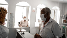 Patient in mask talking to healthcare worker in mask