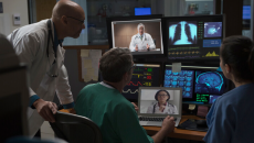 Medical professionals examine screens