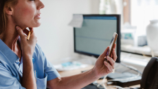 Person holds neck while holding up phone