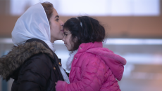 Adult kisses child on forehead