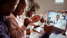 Parent and child talk with doctor via telehealth