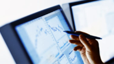 Hand with pen pointing at display screen