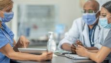 Healthcare worker showing tablet to others