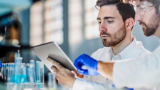 Two scientists use a tablet to review data