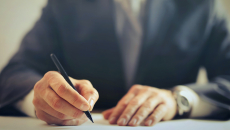 A person writing a letter