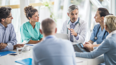 Medical professionals discussing with business people in a hospital meeting