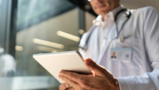 Close-up of doctor lookin at data on a tablet