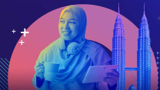 Person with mug and tablet and Petronas Towers in background