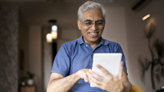 Person smiles as they use an app on a tablet.