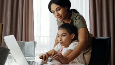 A parent and child look at a computer