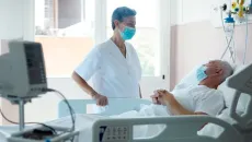 doctor speaks to a hospital patient in bed