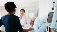 A patient and their family member speaking to a doctor in the hospital