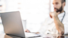 Doctor reviews patient appointments on a laptop
