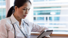 A doctor reading a patient's medical record through a digital tablet