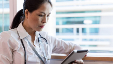 A doctor reading from a tablet computer