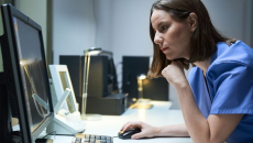 A hospital staff analysing a report on a desktop computer