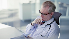 A doctor reading from a digital tablet.