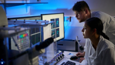Lab researchers viewing graphs on a desktop computer
