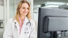 A doctor viewing a patient's file on a desktop computer