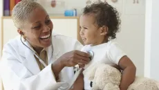 Pediatrician listens to baby's heart with stethoscope