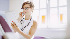 A doctor on a call while checking a patient's digital record