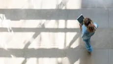 Individual walking uses a tablet to access medical records