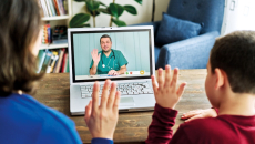 A parent and their child in a virtual consultation with a doctor