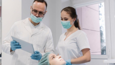 A dentist and an assistant are preparing for a dental procedure