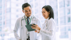 Two doctors discussing a patient's case using a digital tablet