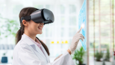 A researcher wearing virtual reality glasses, pointing to a virtual screen