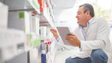 A pharmacist holding a digital tablet doing an inventory