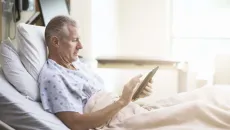 Patient in hospital bed with tablet