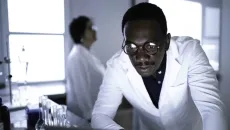 Lab worker leaning over table