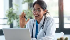 Doctor speaks to a telehealth patient on her laptop 