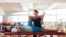 A physical therapist holding up a patient's leg