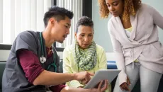 Provider, patient and caregiver look at medical images on a tablet