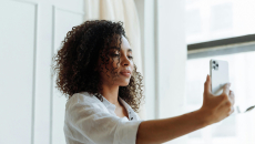 Woman in white shirt takes selfie