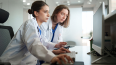 Two healthcare clinicians consult AI data 