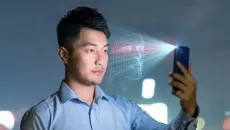 Man holds cell phone up for facial identification