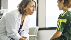 Doctor speaks to child in exam room